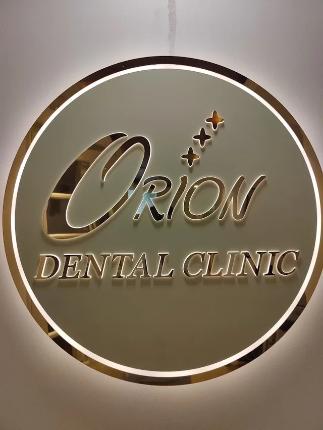 The illuminated Orion Dental Clinic sign on the wall inside the clinic